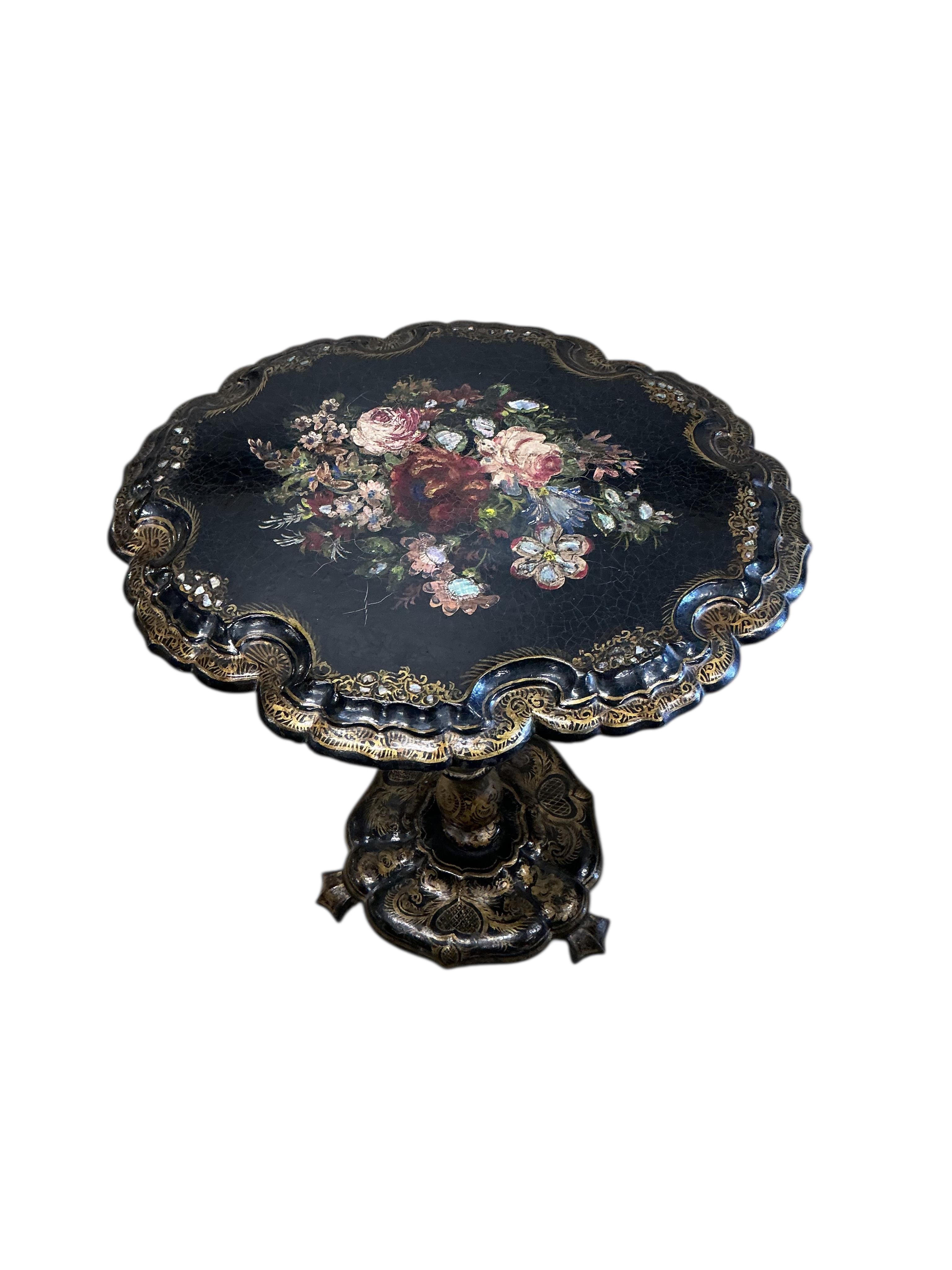A Victorian mother of pearl inlaid papier-mâché oval tilt top wine table, width 58cm, height 67cm, and a similar cane seat chair